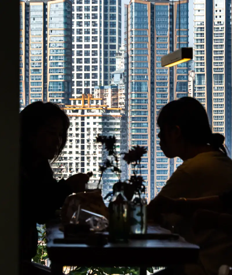 Two people standing at a window with the Chicago skyline below them