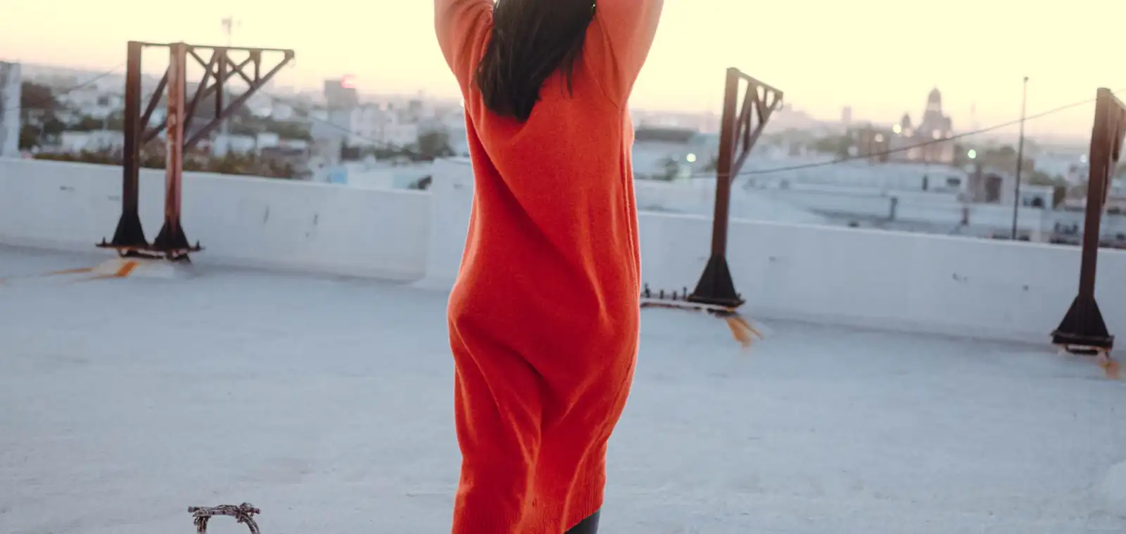 A woman in a structured coat on a Chicago rooftop as the light drops